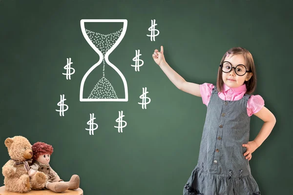 Cute little girl wearing business dress and showing a time concept on green chalk board. — Stock Photo, Image