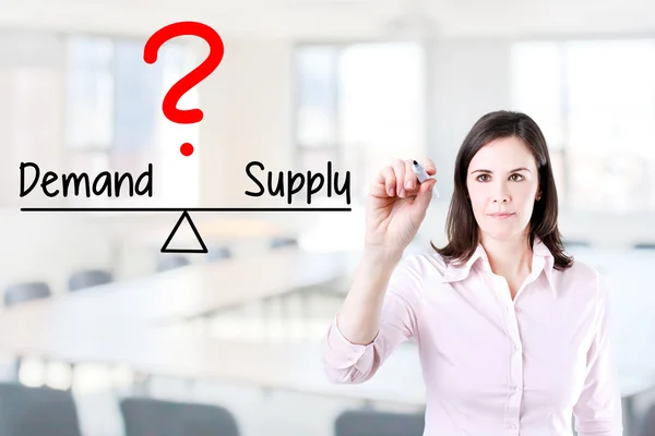 Young business woman writing demand and supply compare on balance bar. — Stock Photo, Image