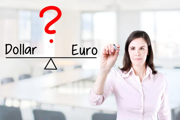 Jonge zakelijke vrouw schrijven dollar en euro vergelijken op evenwicht balk. — Stockfoto