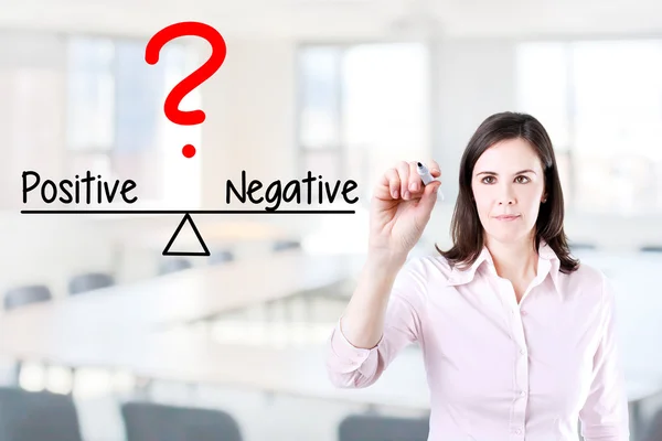 Ung affärskvinna skriva positiva och negativa jämför på balans bar. — Stockfoto