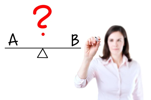 Young business woman writing A and B compare on balance bar. — Stock Photo, Image