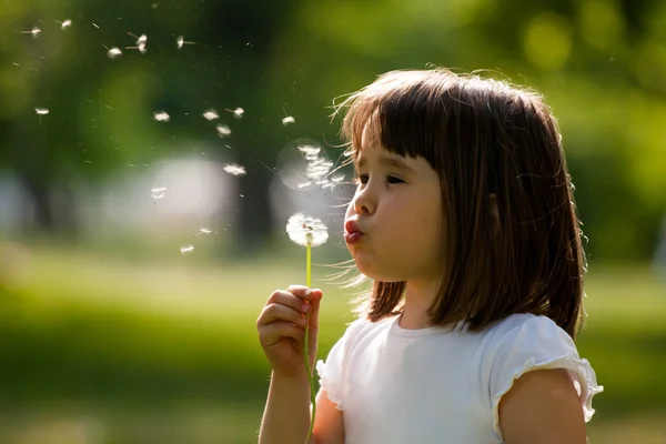 Beautiful child with dandelion flower in spring park. Happy kid having fun outdoors. — Stock Photo, Image