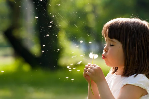 Beautiful child with dandelion flower in spring park. Happy kid having fun outdoors. — Stock Photo, Image