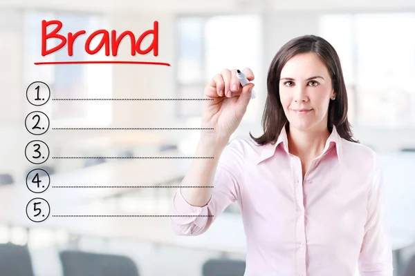 Business woman writing blank Brand list. Office background. — Stock Photo, Image