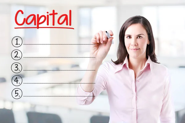 Geschäftsfrau, die eine leere Kapitalliste schreibt. Hintergrund Büro. — Stockfoto