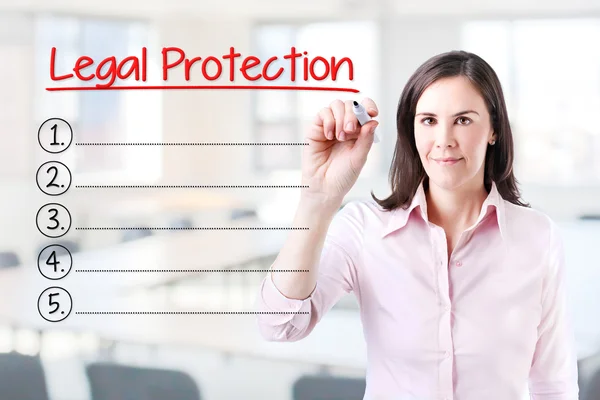 ビジネスの女性は、法的保護の空白のリストを書きます。事務所の背景. — ストック写真