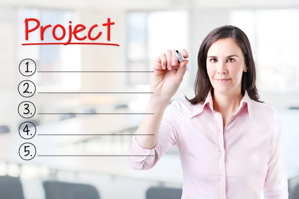 Geschäftsfrau schreibt leere Projektliste. Hintergrund Büro. — Stockfoto
