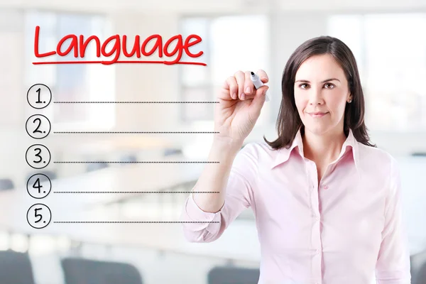 Business woman writing blank Language list. Office background. Royalty Free Stock Photos