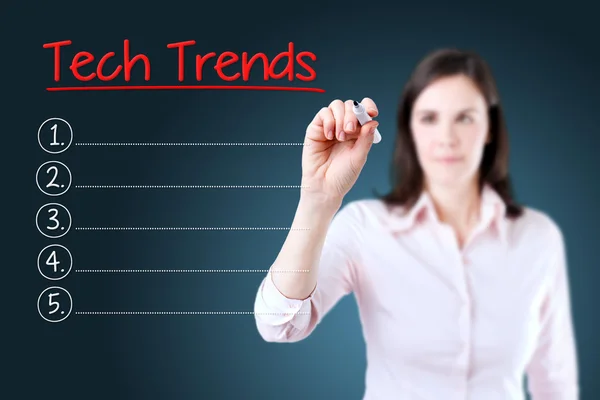 Business woman writing blank Tech Trends list. Blue background. — Stock Photo, Image