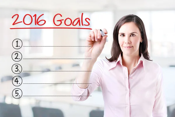 Business woman writing blank 2016 Goals list. Office background. — Stock Photo, Image