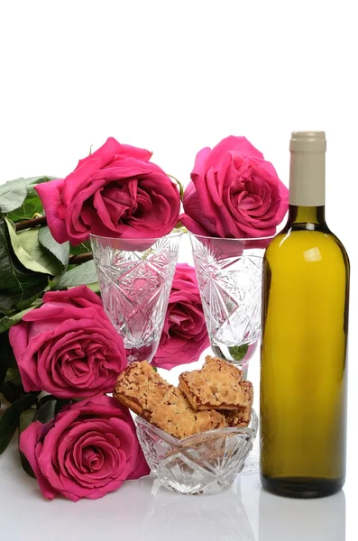 Bicchieri di cristallo, una bottiglia di vino, biscotti e un mazzo di rose in una natura morta — Foto Stock