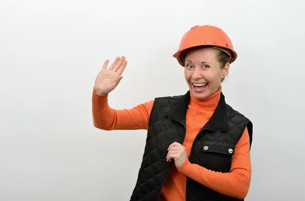 Vrouw bouwer verwelkomt u, bedrijf in zijn hand en glimlachen — Stockfoto