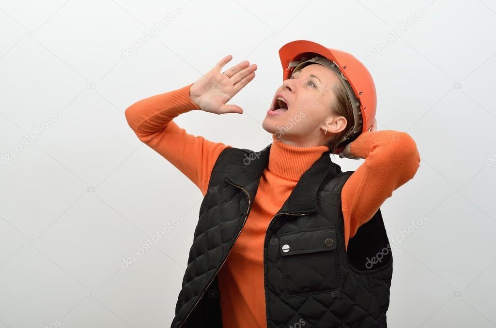 Female construction worker in a hardhat shouts loudly