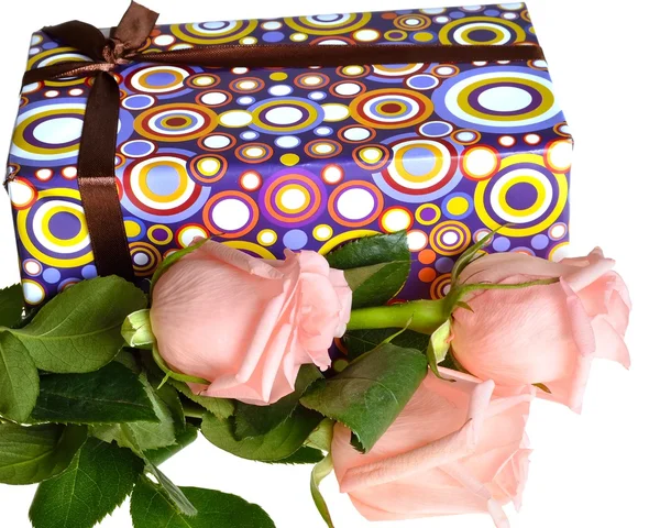 Три красивые розовые розы и подарочная коробка лежит на белом фоне — стоковое фото