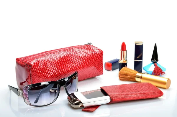Женская косметическая сумка, мобильный телефон, солнцезащитные очки, косметика лежат на белом фоне — стоковое фото