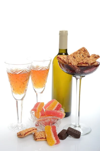 Bottle of wine, crystal glasses, cookies in a vase and marmalade candy for two served with — Stock Photo, Image