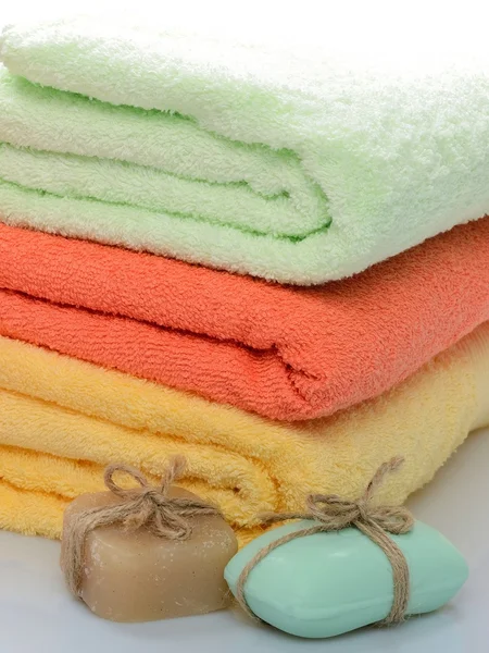 Natura morta: asciugamani colorati e sapone per la cura del corpo, spa, bagno e sauna su sfondo bianco — Foto Stock