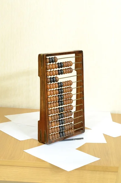 Antieke houten abacus voor accountants op tafel, vellen papier en een pen in stilleven — Stockfoto