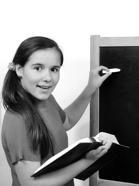 Jeune fille adolescent élève écrit sur le tableau noir leçon de craie — Photo
