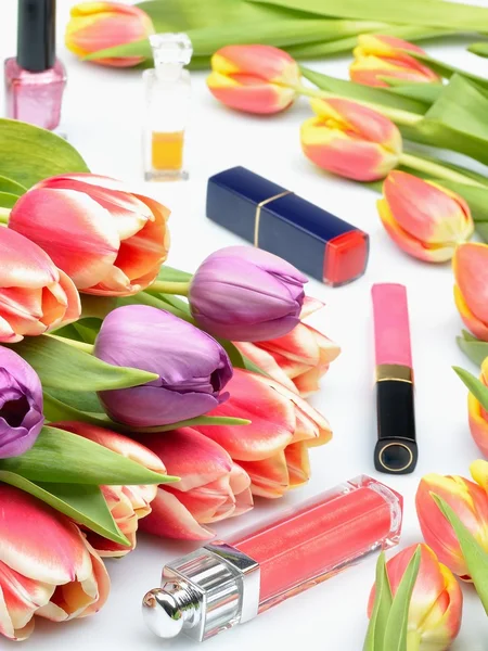 Flores coloridas tulipas e itens de maquiagem e cosméticos para mulheres em um fundo branco — Fotografia de Stock