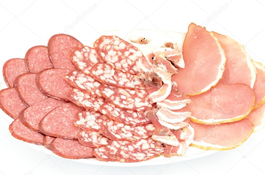 Plate with delicious the delicacies pieces of meat, sausages and bacon on a white background