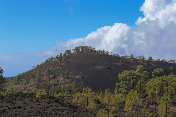 The hardened lava of the volcano on the background of blue sky. — Stock Photo, Image