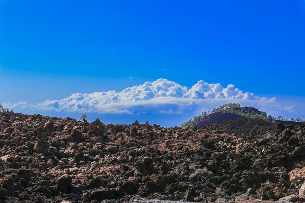 The hardened lava of the volcano on the background of blue sky. — Stock Photo, Image