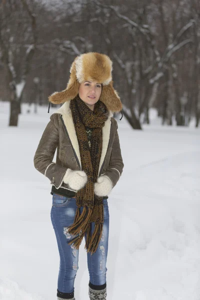 Schönheit Mädchen in frostigen Winter Park. Draußen. fliegende Schneeflocken. — Stockfoto