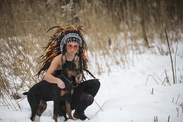 Tjej med en hund i vinter skog — Stockfoto