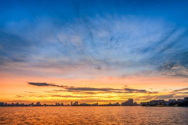 Hanoi, Vietnam 'daki Batı Gölü' nün göz kamaştırıcı panoramik manzarası renkli bir günbatımı gökyüzünün altında parlıyordu..