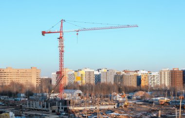 Kırmızı ve Beyaz Kule Vinç modern binaların zemin karşı bir inşaat sahasında bina. Vinç üzerinde odaklanmak