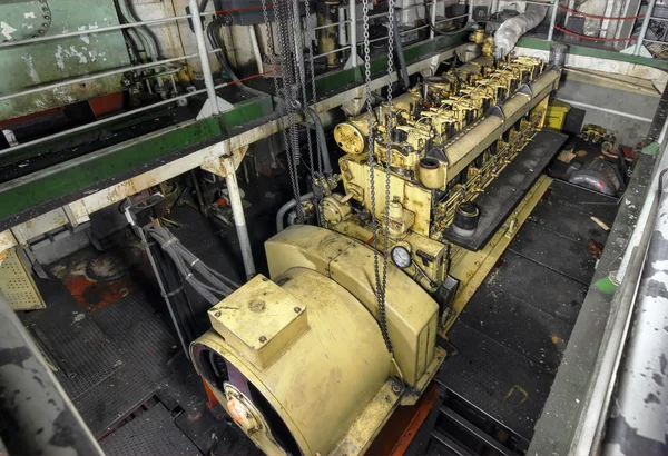 La bodega de la nave con motor diesel amarillo montado en la nave. Sala de máquinas en un viejo barco de carga . — Foto de Stock