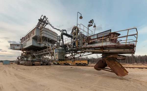 Viele Eimer mit riesigen Baggergeräten für die Sandgewinnung aus dem Steinbruch. zurück lizenzfreie Stockfotos