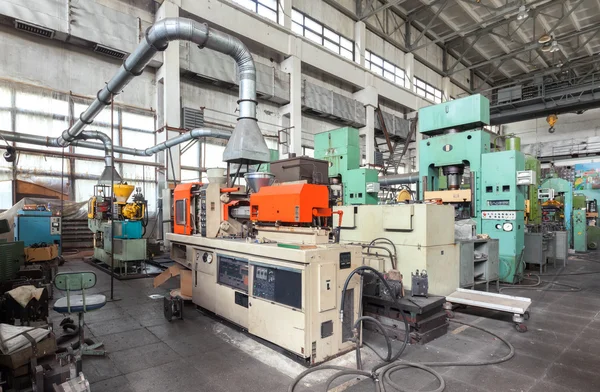 Machinery plant. Workshop for production of  thermoplastic parts. Injection molding plastic machine and hydraulic press — Stock Photo, Image