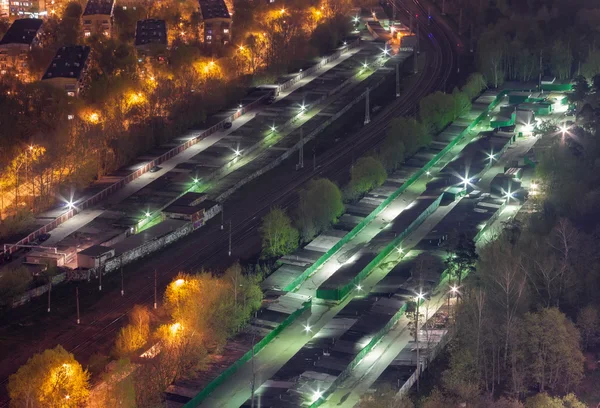 Top view car garages divided by the railroad on the outskirts of the city, at night
