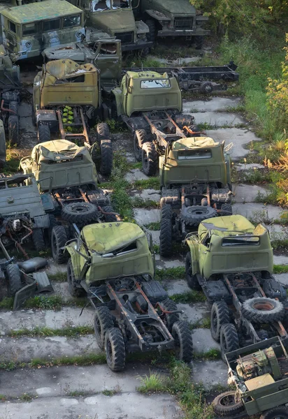 Група іржавих старих армійських вантажівок покинула на бетонній платформі — стокове фото