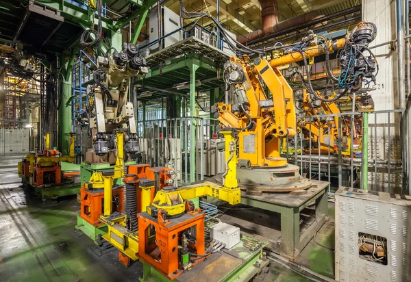 İflas ve terk edilmiş otomobil fabrikası. Sarı robotlar bir üretim hattı otomobillerde kaynak.