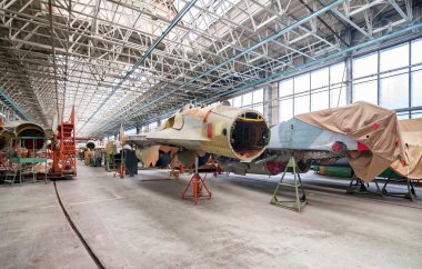 Aviation factory of military aircraft. Assembly of the Russian fighter. Focus on the cockpit clipart
