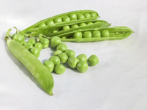 Los guisantes verdes y la fruta del guisante la legumbre sobre blanco . — Foto de Stock