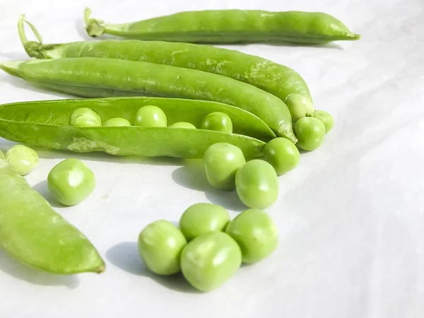 Piselli verdi e frutto di pisello il legume su bianco . — Foto Stock