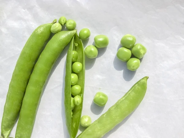 Los guisantes verdes y la fruta del guisante la legumbre sobre blanco . — Foto de Stock