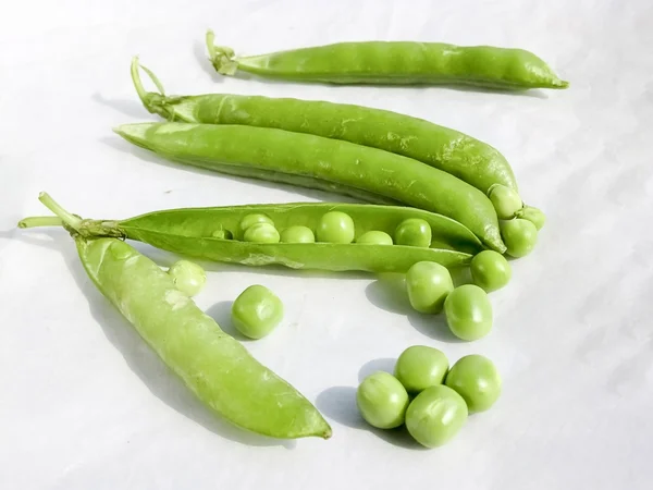 Los guisantes verdes y la fruta del guisante la legumbre sobre blanco . — Foto de Stock