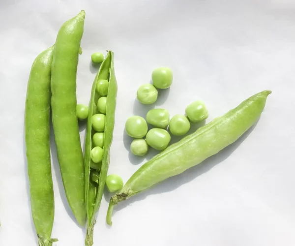 Los guisantes verdes y la fruta del guisante la legumbre sobre blanco . — Foto de Stock