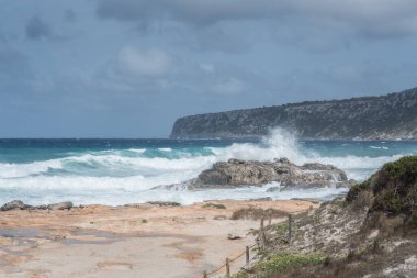 Deniz Burnu. Dalgaların kıyıdaki kayalara şiddetle çarpmasıyla dalgalı bir deniz günü. Formentera Adası, İspanya.