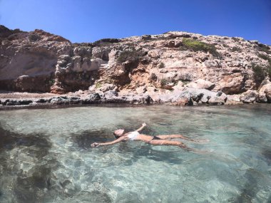 Deniz suyunda yüzen bir kadın, çok rahat. Formentera adası. İspanya.