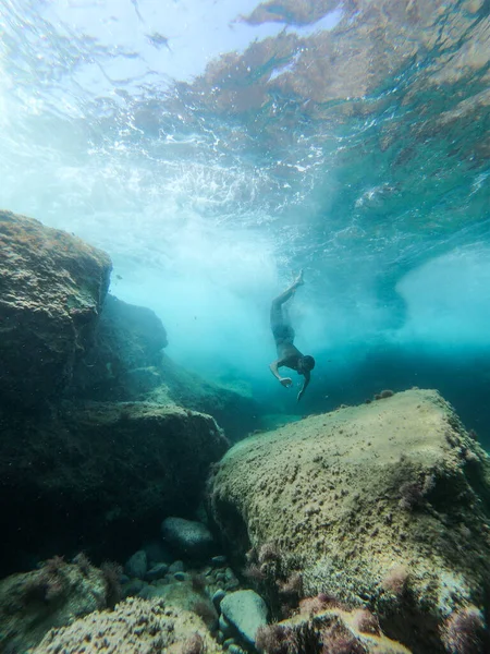 Man diving into the sea. View from inside the water.