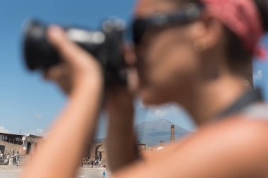 Volkan Vesuvius 'un İtalya' nın Pompeii kentindeki Roma arkeolojik forumundaki görüntüsü, bir kadın fotoğrafçının kolları aracılığıyla (seçici odak noktası)).