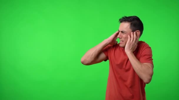 Man annoyed by noise. Chroma green background. — Stock Video