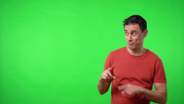 男は何かを発表し、脇を指している。クロマグリーンの背景. — ストック動画