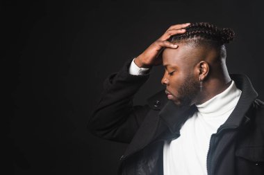 Siyahi adam profilinde, eli alnında..